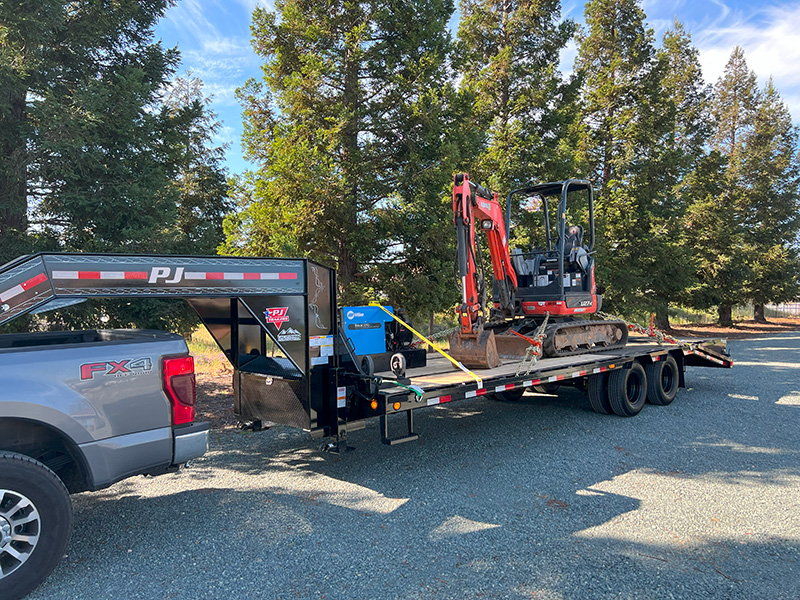 excavator being towed on a trailer