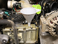 refilling the reservoir with new motor oil